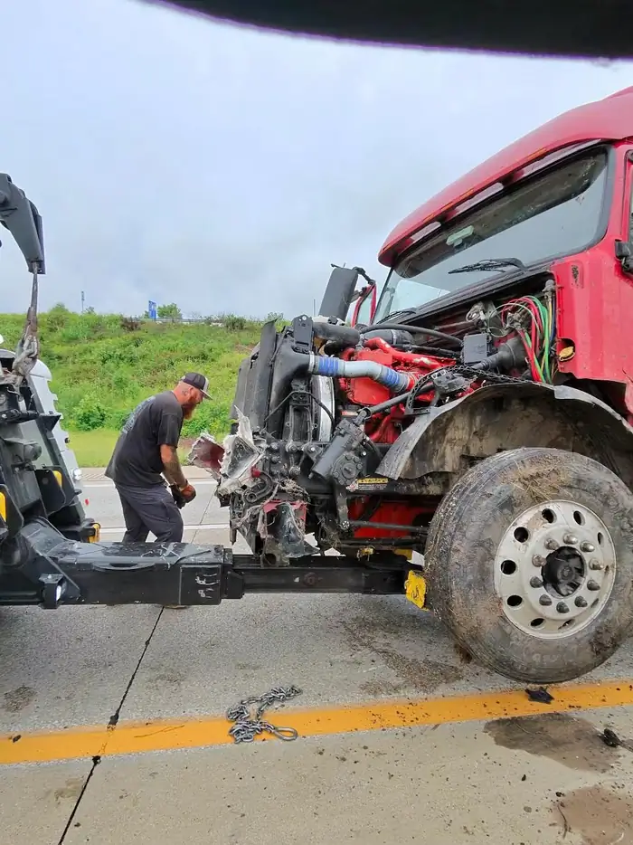 Roadside repair on a damaged tractor engine bay.