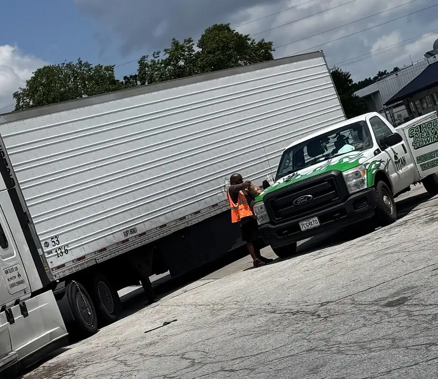 Titan service truck and technician alongside a loaded dry van trailer.