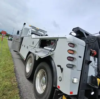 Titan heavy wrecker with the boom deployed and tool compartment open.